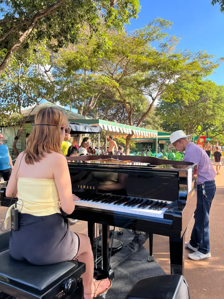 Pianista e público de todas as idades ao redor do Piano Bike preto