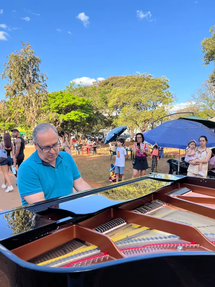 Piano Bike preto de tampa aberta cercado pelo público no parque
